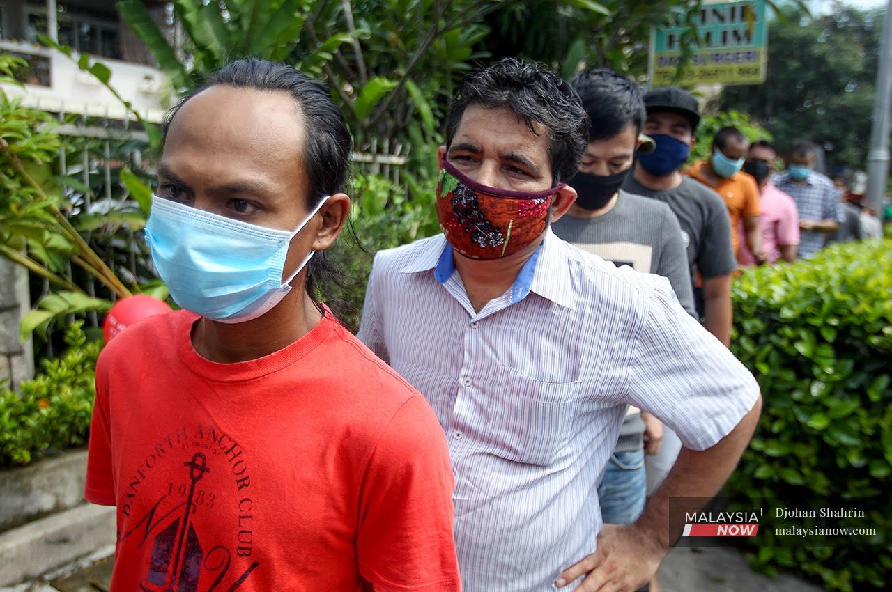 Foreigners working at the Chow Kit market wait in line to be screened for Covid-19 on May 8.