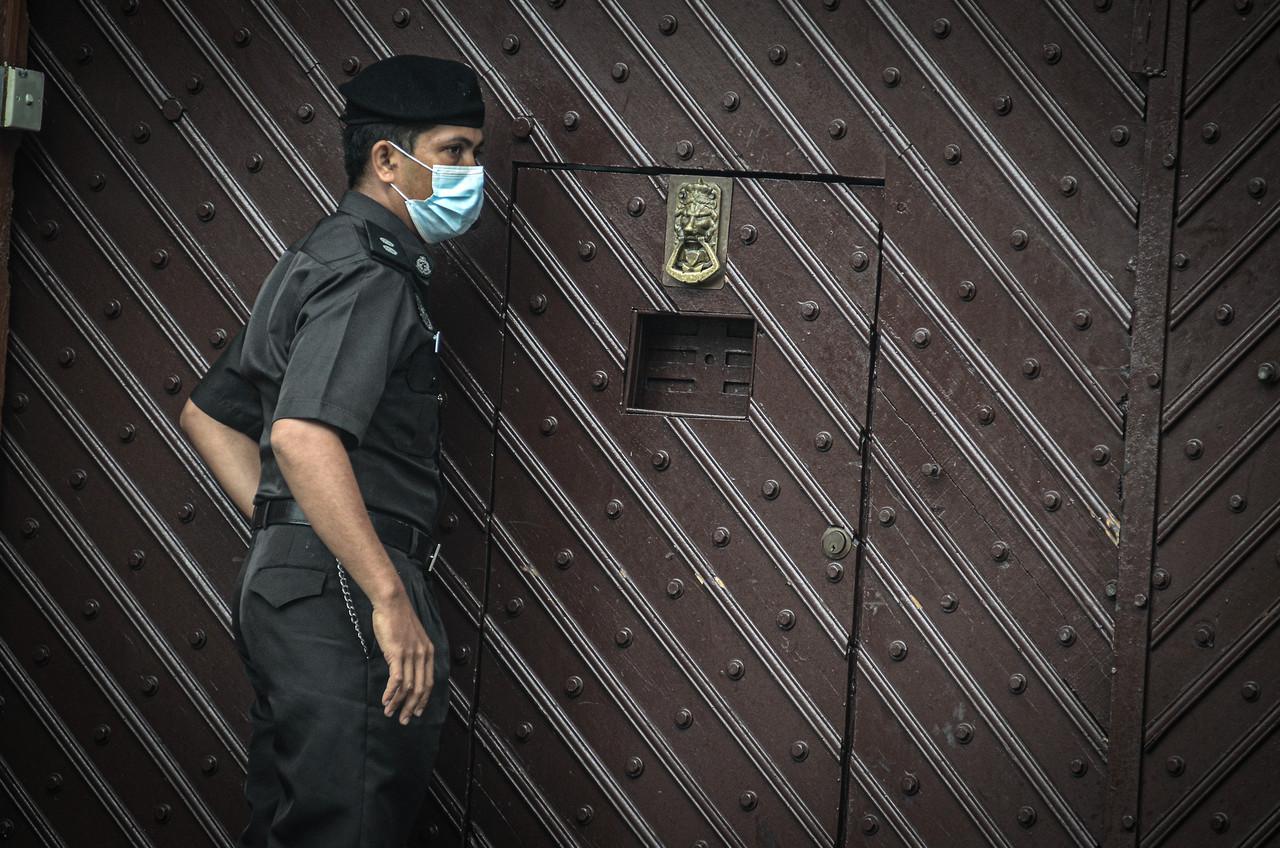 A member of staff stands outside the Penang remand prison in George Town, which has recently seen spikes in Covid-19 cases. Photo: Bernama