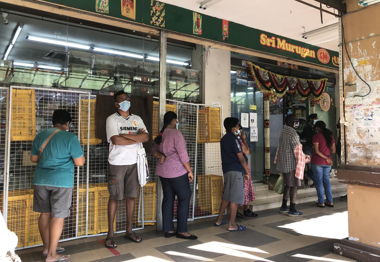 Residents in Klang line up outside a hypermarket to buy food and other essential items before the conditional lockdown kicks in. Photo: Bernama