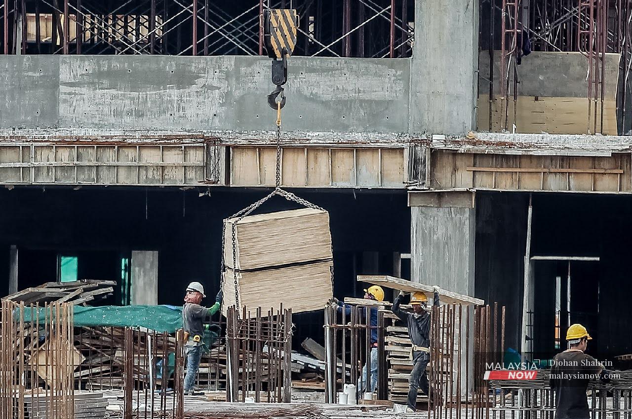Buruh binaan melakukan kerja-kerja pembinaan di Jalan Sungai Besi di Kuala Lumpur.