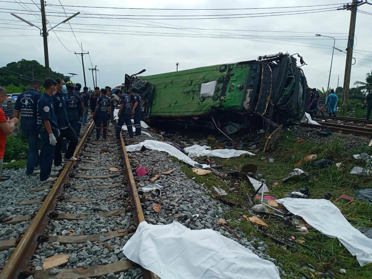 Rescuers stand by a damaged train and bodies covered with white sheets after a bus-train collision in Chacheongsao province, 80km east of Bangkok, on Oct 11. Photo: AP