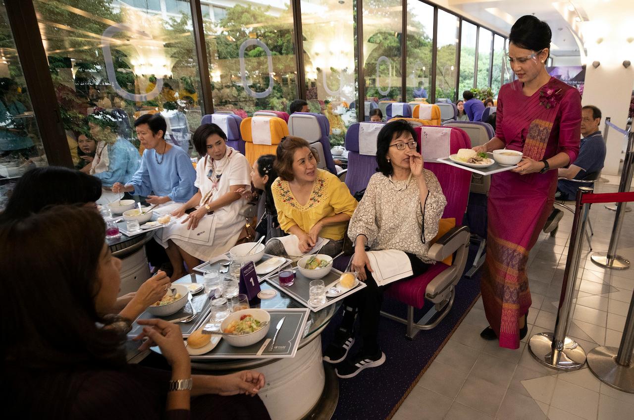 A flight attendant serves meals in a flight-themed restaurant at the Thai Airways head office in Bangkok on Oct 3, 2020. The airline is trying to boost staff morale, polish its image and bring in a few pennies, even as it juggles preparing to resume international flights while devising a business reorganisation plan. Photo: AP