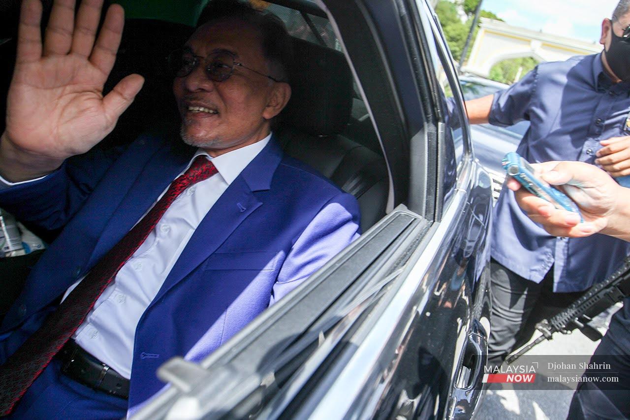 PKR president Anwar Ibrahim waves as he leaves Istana Negara today after his audience with the Agong.