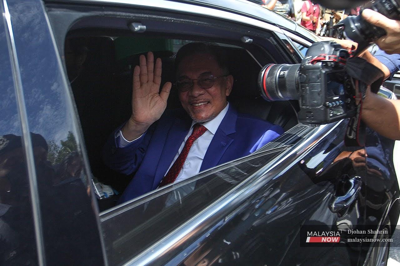 PKR president Anwar Ibrahim waves as he leaves Istana Negara after his audience with the Agong on Oct 13.