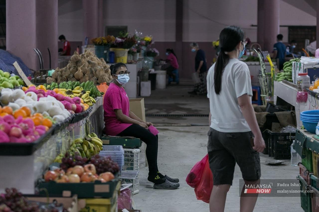 Seorang peniaga di Pasar Borong Klang memakai pelitup muka bagi mematuhi SOP yang ditetapkan oleh Kementerian Kesihatan.