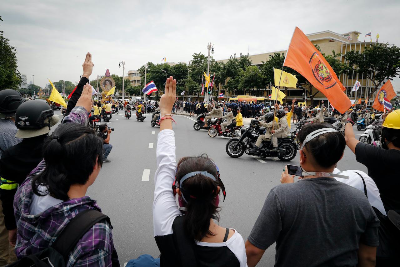 Anti-government protesters raise three-finger salutes, a symbol of resistance, during a protest near the Democracy Monument in Bangkok, Thailand on Oct 14. Photo: AP