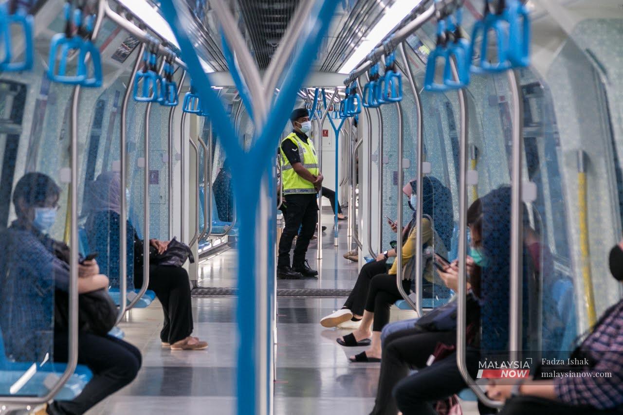 Auxiliary police conduct checks in an MRT carriage in the Klang Valley on Oct 14, the first day of the conditional movement control order.