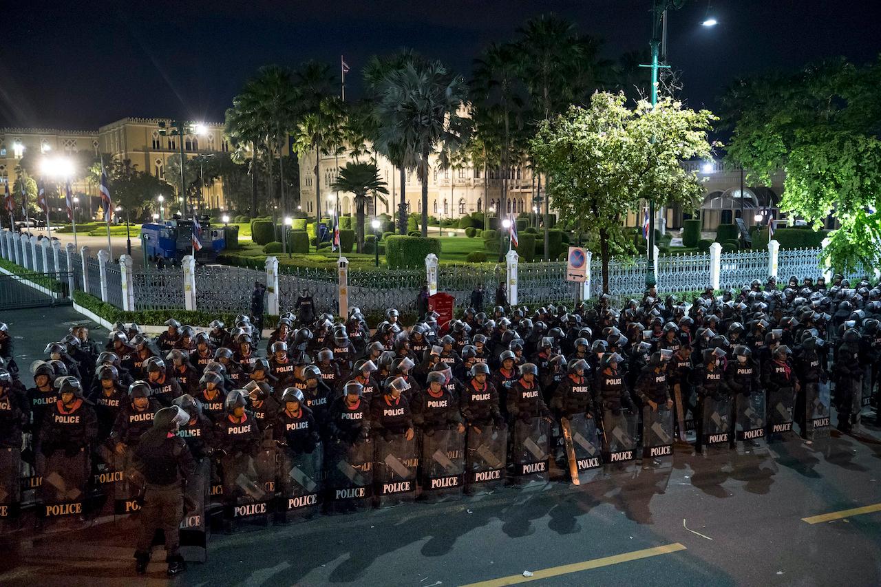 Riot police stand with riot shields to disperse pro-democracy protesters outside the Government House in Bangkok, Thailand on Oct 15. Photo: AP