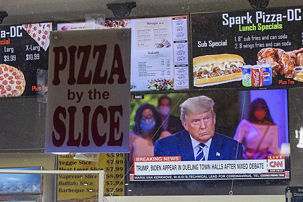 President Donald Trump is seen through a television at a takeout pizza shop as he speaks during a town hall on Oct 15 in Washington, DC. Photo: AFP