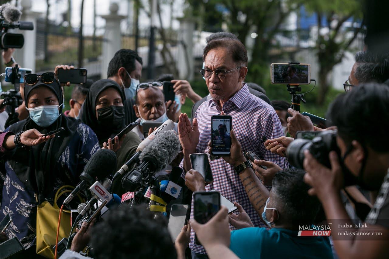 PKR president Anwar Ibrahim speaks to reporters outside the Bukit Aman police headquarters in Kuala Lumpur today.