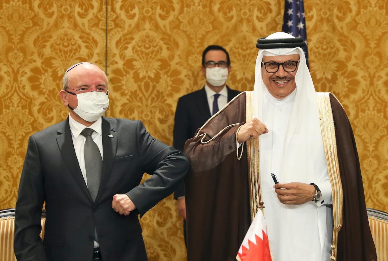 Israel's national security adviser, Meir Ben-Shabbat (left) bumps elbows with Bahrain's Foreign Minister Abdullatif al-Zayani after signing an agreement in Manama, Bahrain on Oct 18. Photo: AP