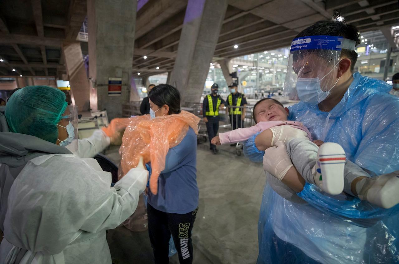 A public health worker helps a group of Chinese tourists who arrived at Suvarnabhumi airport on special tourist visas, in Bangkok, Thailand, Oct 20. Photo: AP
