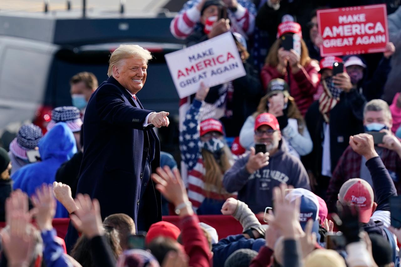 President Donald Trump points to supporters as he leaves a campaign rally at Manchester-Boston Regional Airport, Oct 25. Photo: AP