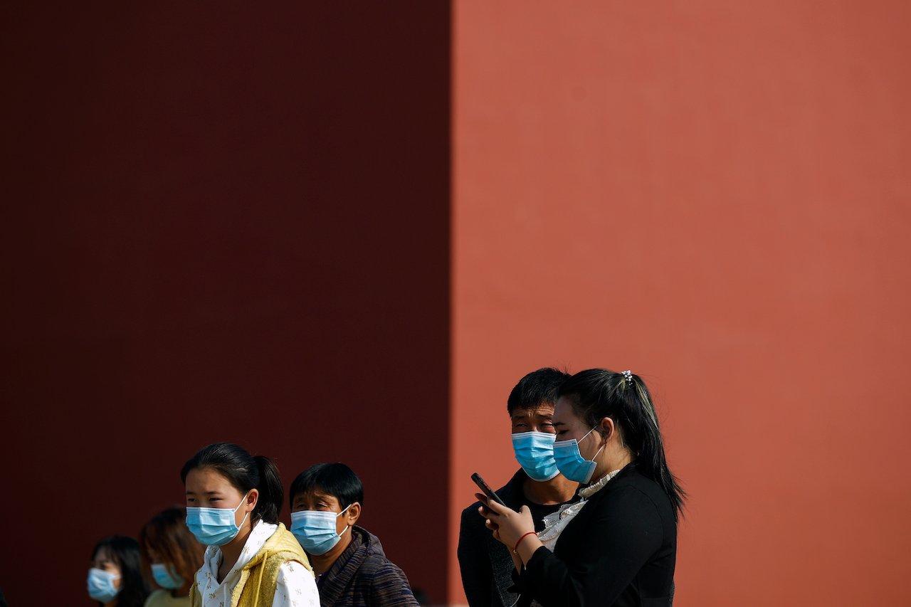 Tourists wearing face masks to help curb the spread of the coronavirus visit the Forbidden City in Beijing, Oct 25. Photo: AP