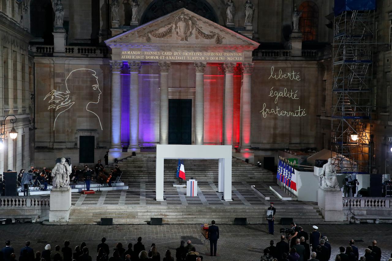French President Emmanuel Macron pays his respects at the coffin of slain teacher Samuel Paty in the courtyard of the Sorbonne university during a national memorial event, Oct 21 in Paris. Photo: AP