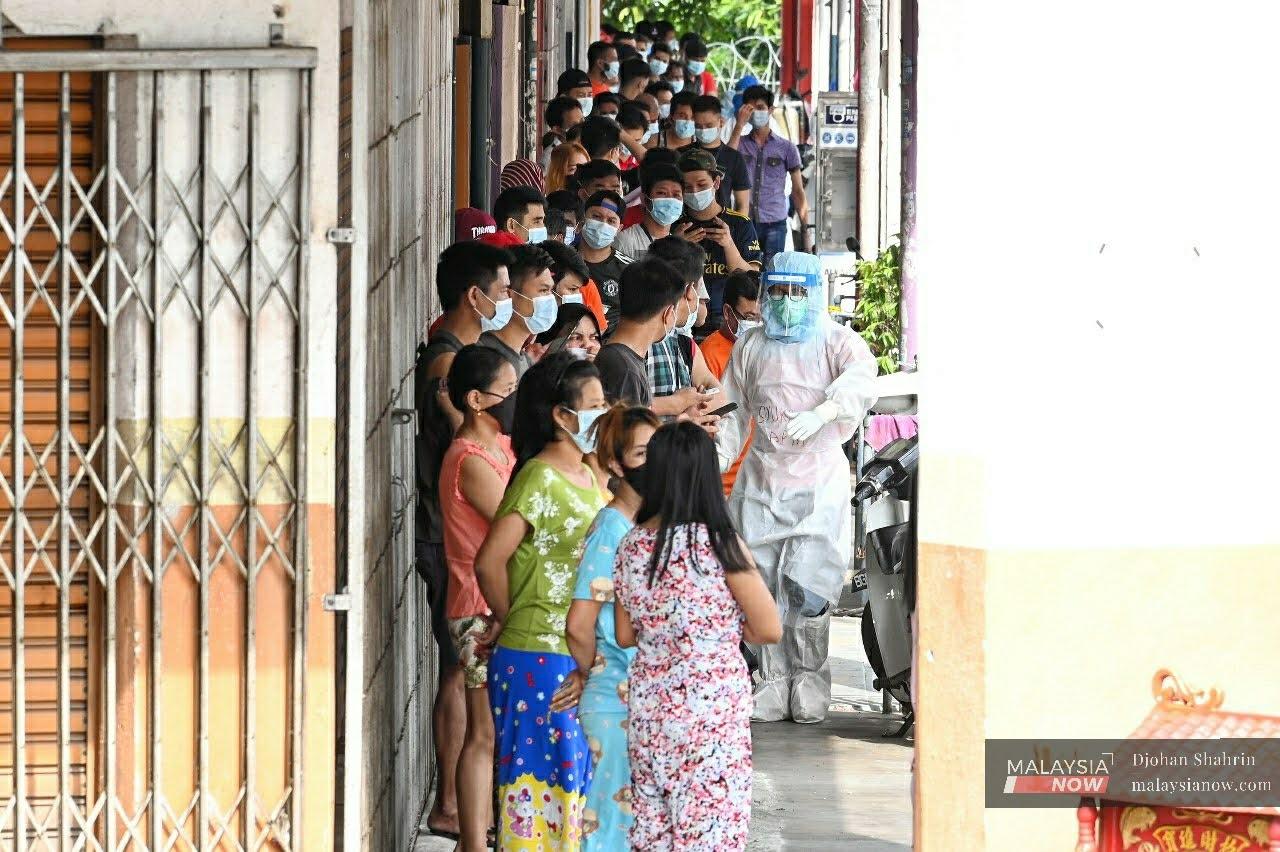 Residents at Plaza Hentian Kajang, which is under enhanced movement control order, queue to be screened for Covid-19.
