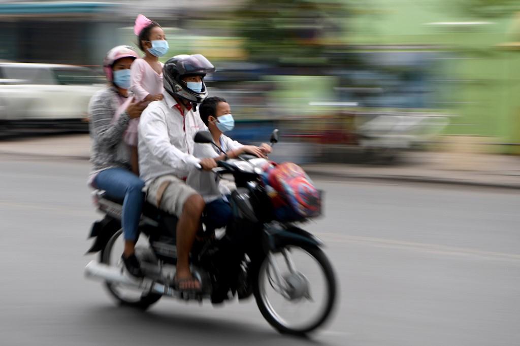 Members of a family wear face masks as a preventive measure against the spread of Covid-19 as they ride their motorcycle along a street in Phnom Penh on April 28. Photo: AFP