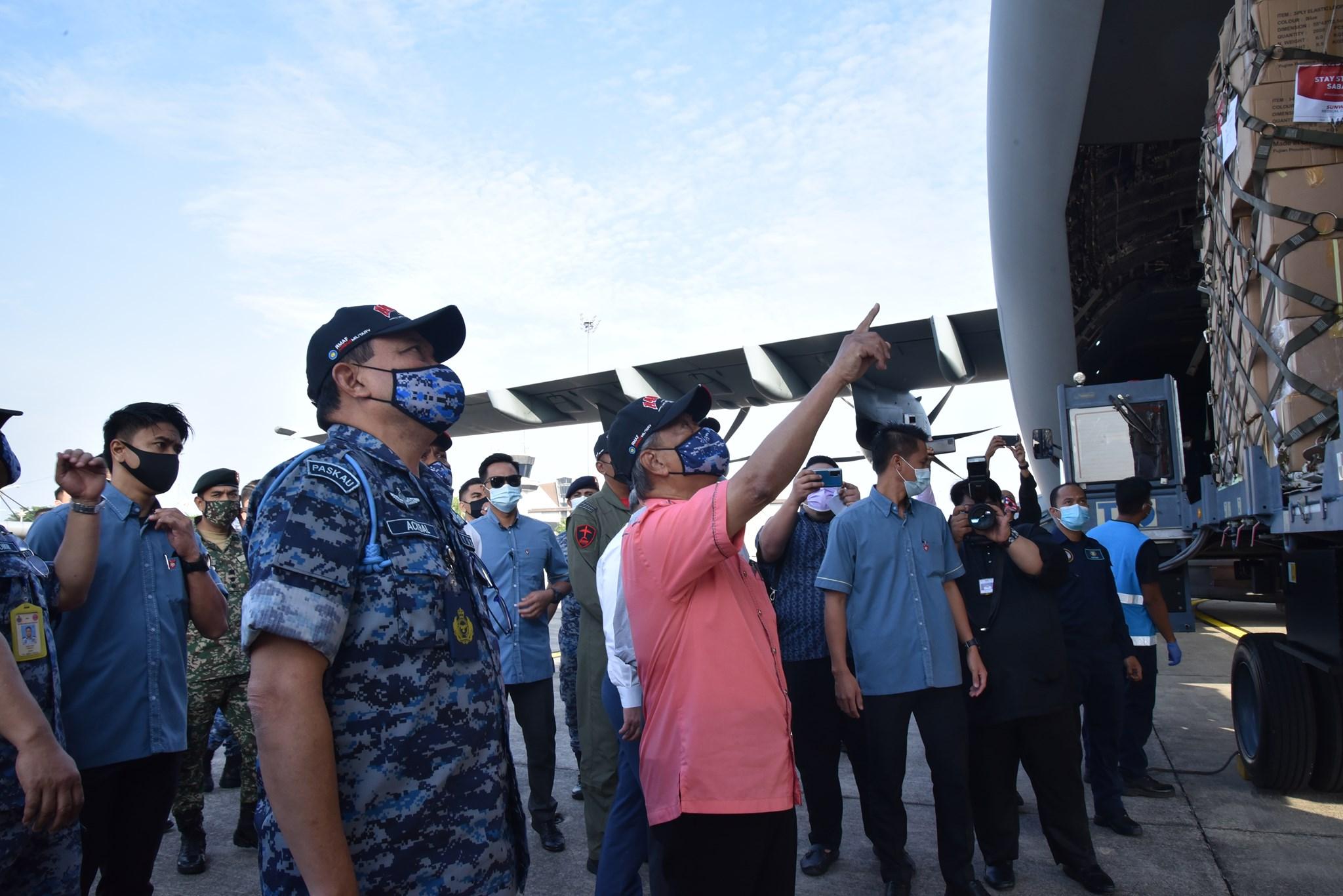 Perdana Menteri Muhyiddin Yassin (dua dari kiri) melihat persiapan misi bantuan ke Sabah di Pangkalan Udara Subang. Gambar: Facebook