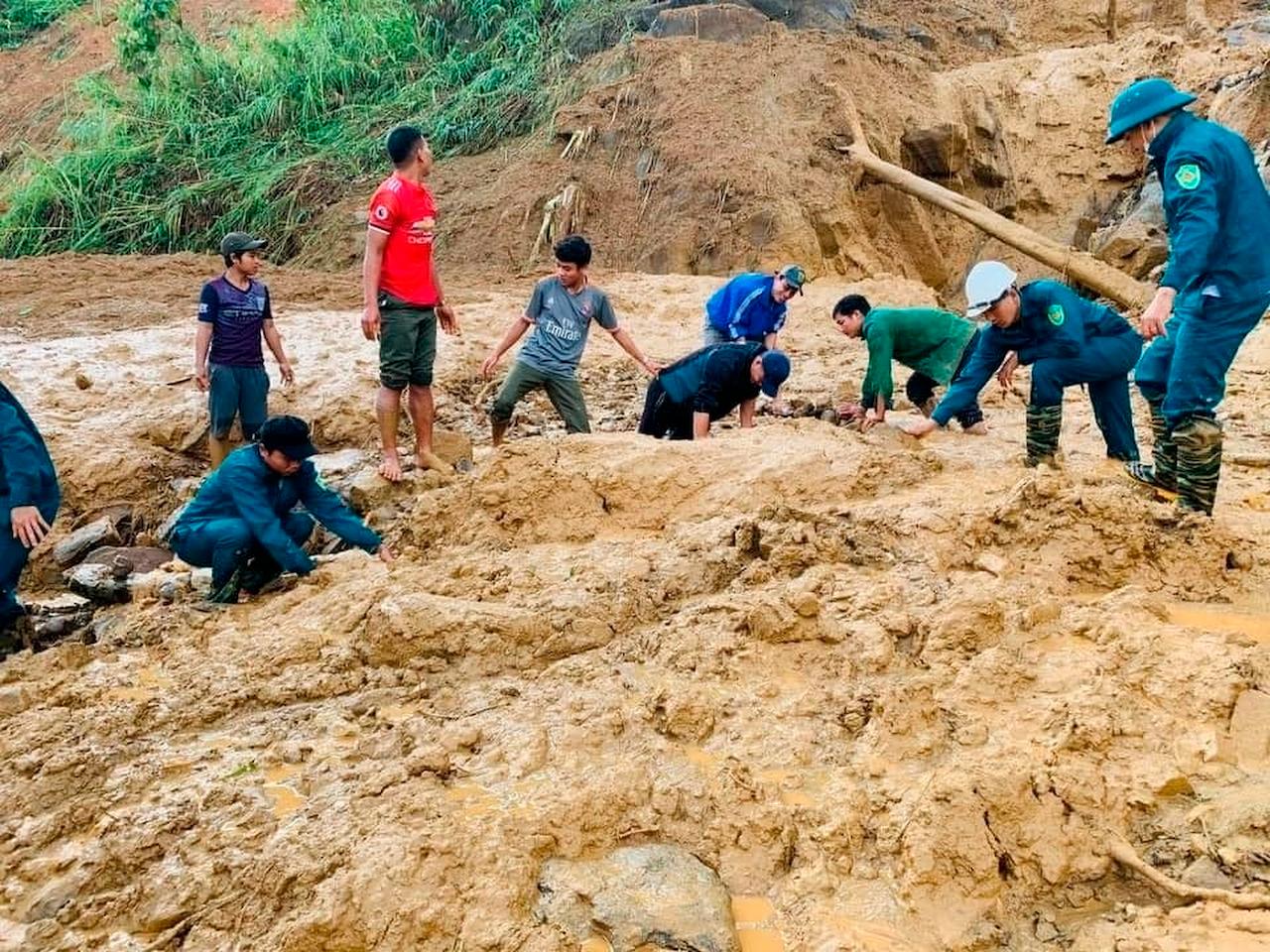 Soldiers and villagers dig through mud after a landslide swamps a village in Phuoc Loc district, Quang Nam province, Vietnam on Oct 29. Three separate landslides triggered by typhoon Molave killed over a dozen villagers and left dozens more missing in the province. Photo: AP