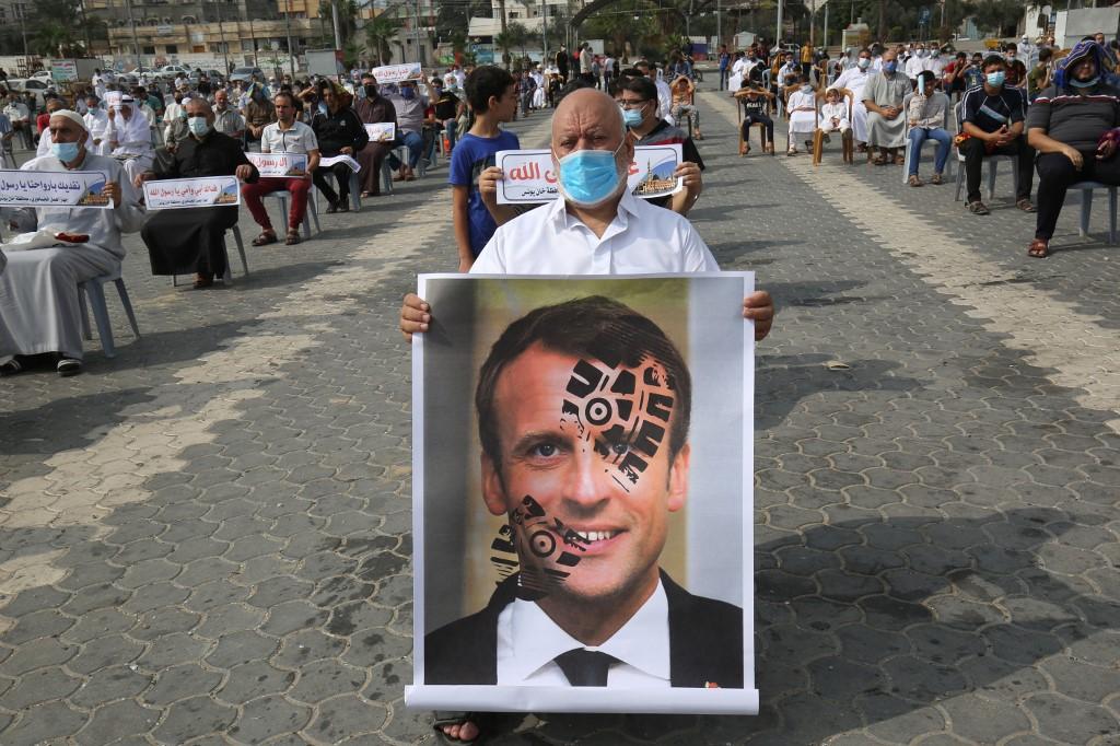 Seorang penduduk Palestin memegang gambar Presiden Perancis Emmanuel Macron sebagai bantahan anti-Islam terhadap pemimpin itu. Gambar: AFP