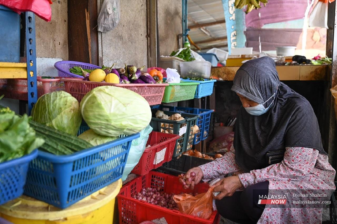 Seorang pelanggan sedang membeli barang keperluan di sebuah kedai runcit di Kampung Pandan, Kuala Lumpur.