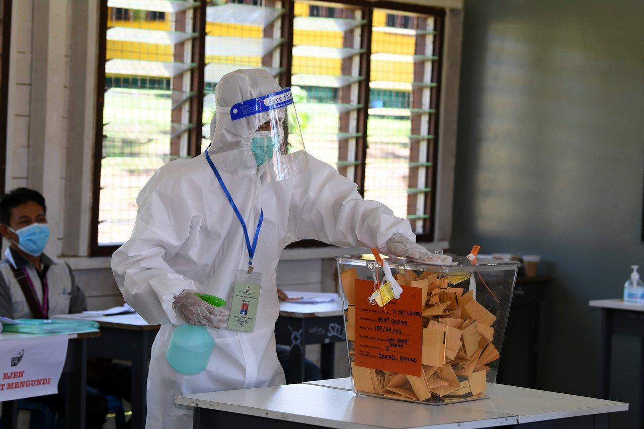 Petugas Suruhanjaya Pilihan Raya (SPR) melakukan kerja pembasmian kuman di kotak undi pada Pilihan Raya Negeri Sabah baru-baru ini. Gambar: Bernama