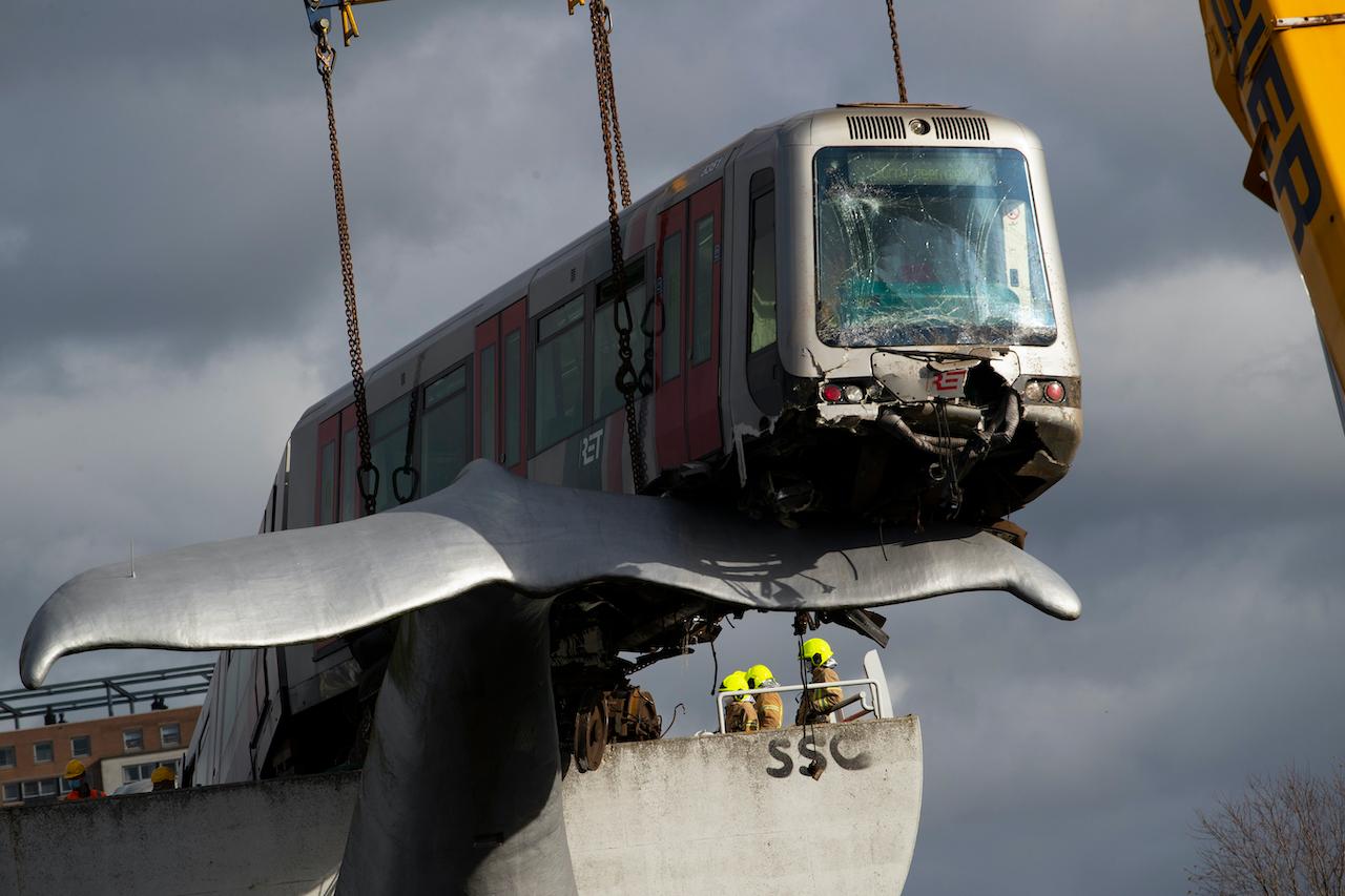 Firefighters inspect a metro carriage which rammed through the end of an elevated section of rails and ended up on the whale's tail of a sculpture in Spijkenisse, near Rotterdam, Netherlands, Nov 3. Photo: AP