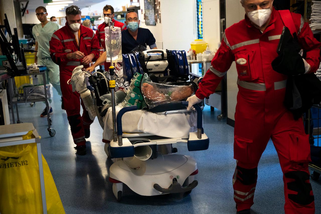 Medical personnel in Belgium wheel a bed with a coronavirus patient as they prepare to transfer the patient by helicopter to another hospital in Germany, Nov 3. Photo: AP