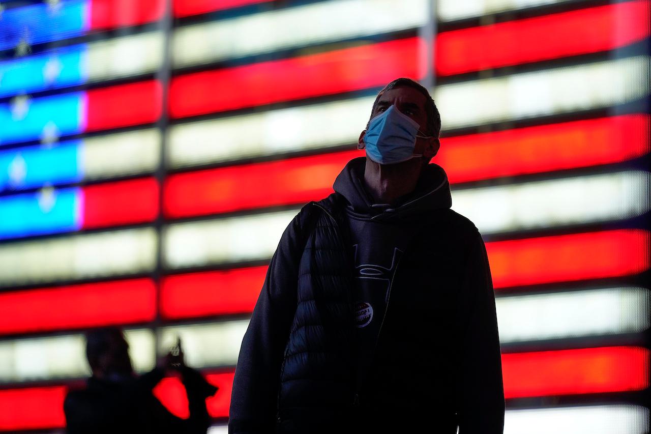 A man stops to watch election returns on electronic billboards in Times Square, Tuesday, Nov 3. Photo: AP