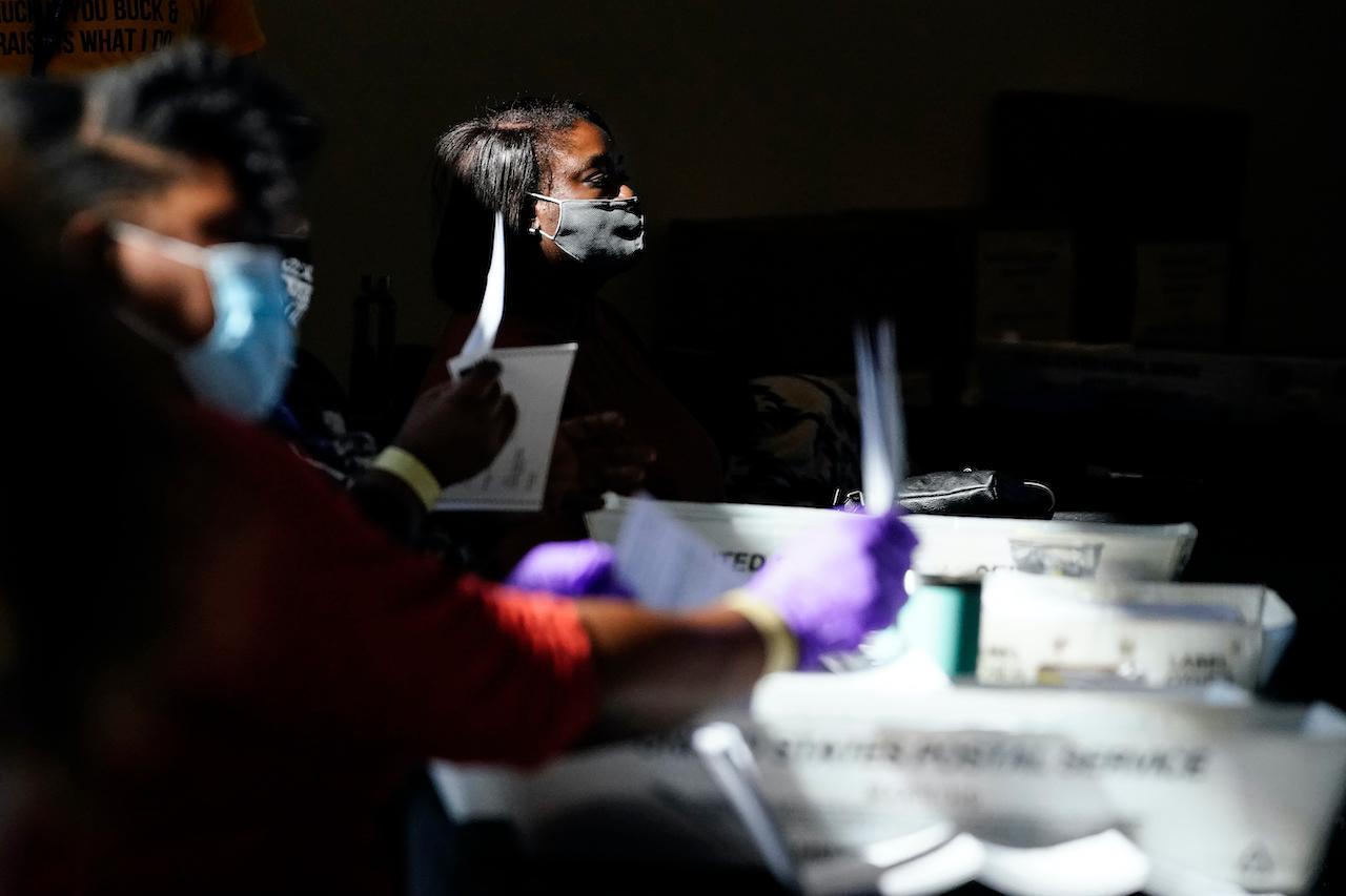 Election personnel examine ballots as vote counting in the general election continues in Atlanta, Nov 4. Photo: AP