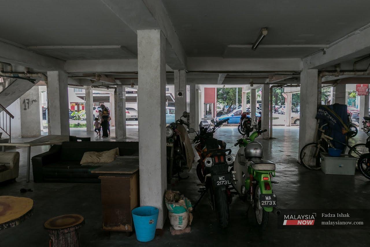 A family exits the parking area of a low-cost flat in Shah Alam.