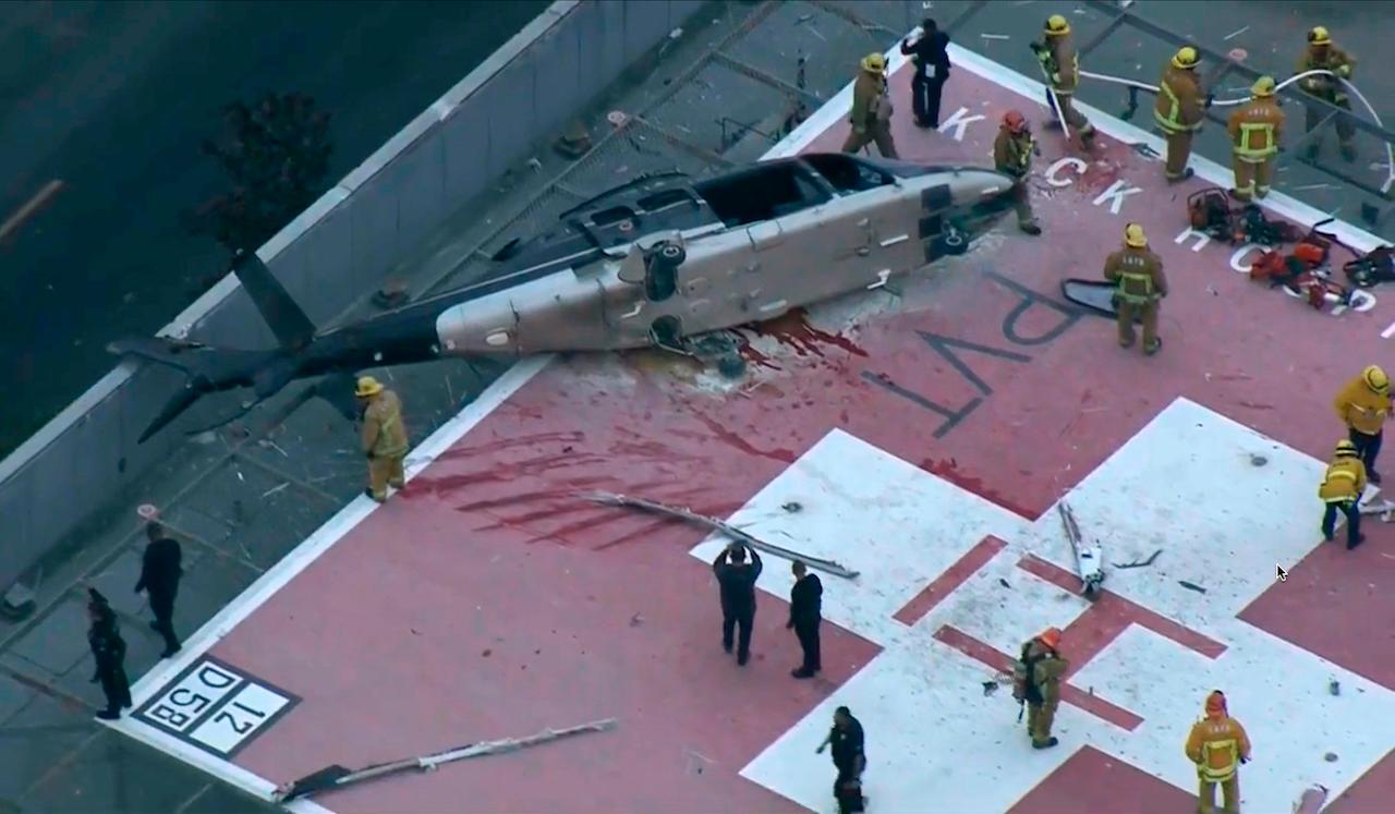 Los Angeles firefighters and other personnel work next to a helicopter that crashed on the helipad at Keck Hospital of the University of Southern California on Nov 6. Photo: AP