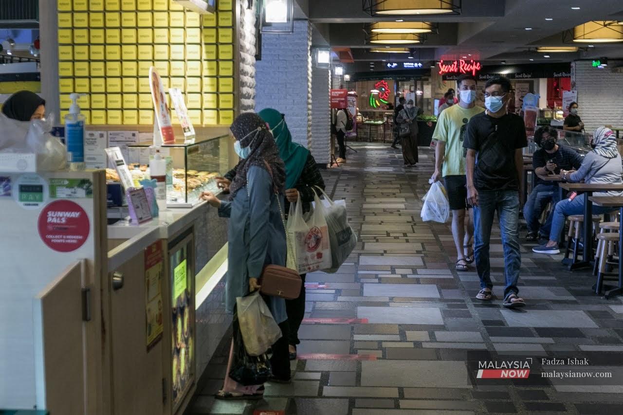 Pengunjung di sebuah pusat beli-belah di Kuala Lumpur dilihat memakai pelitup muka bagi mematuhi SOP yang ditetapkan kerajaan.