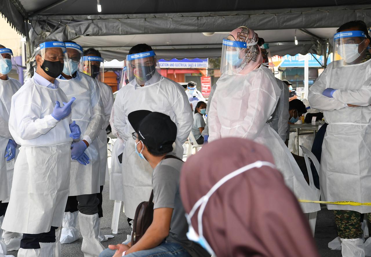 Perdana Menteri Muhyiddin Yassin lengkap memakai sut peralatan perlindungan diri (PPE) ketika membuat tinjauan ke Pusat Saringan Covid-19 di pusat perniagaan Medan 88 Bandar Salak Tinggi. Gambar: Bernama
