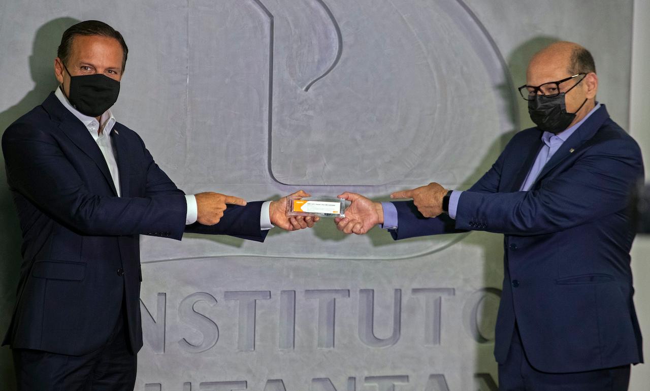 Sao Paulo Governor Joao Doria (left) and Butantan Institute director Dimas Covas hold up a box of an experimental Covid-19 vaccine being tested in partnership with China's pharmaceutical company Sinovac on Nov 9. Photo: AP