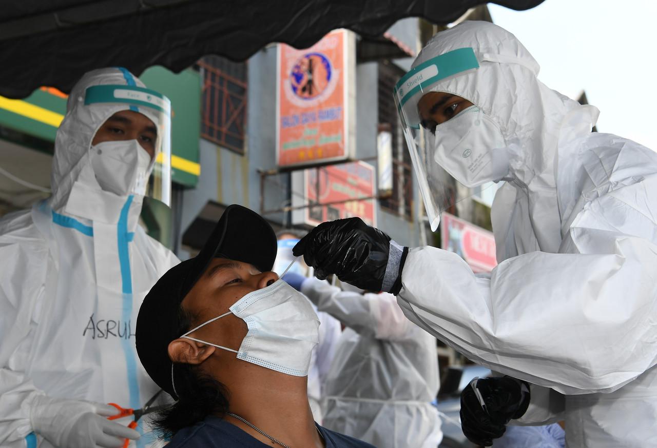 Seorang penduduk Medan 88, Bandar Baru Salak Tinggi melakukan ujian swab selepas kawasan itu dikenakan Perintah Kawalan Pergerakan Diperketatkan. Gambar: Bernama