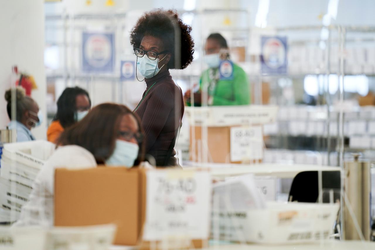Polling workers inspect and count absentee ballots in New York, Nov 10. Photo: AP