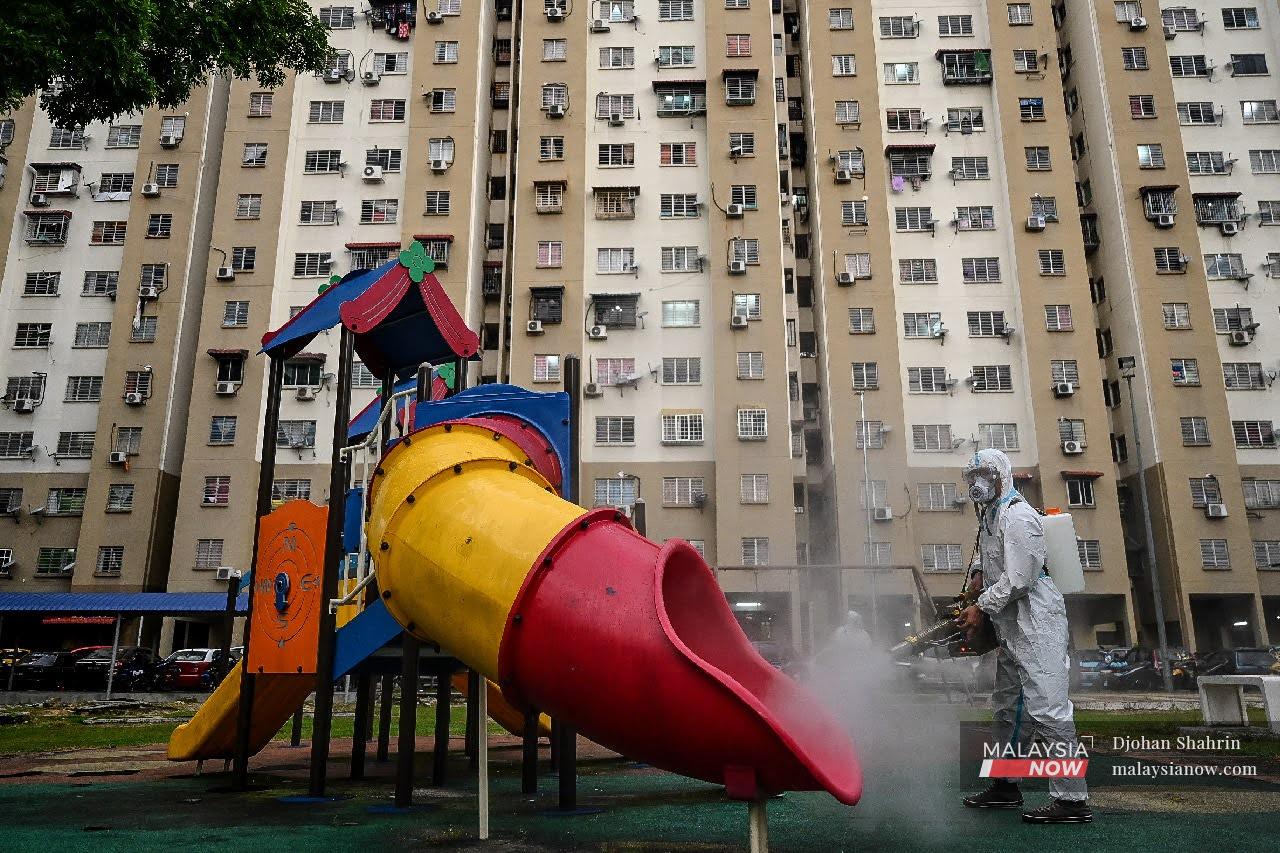 A volunteer sprays sanitiser at the playground of the Pudu Ulu low-cost flats in Kuala Lumpur.