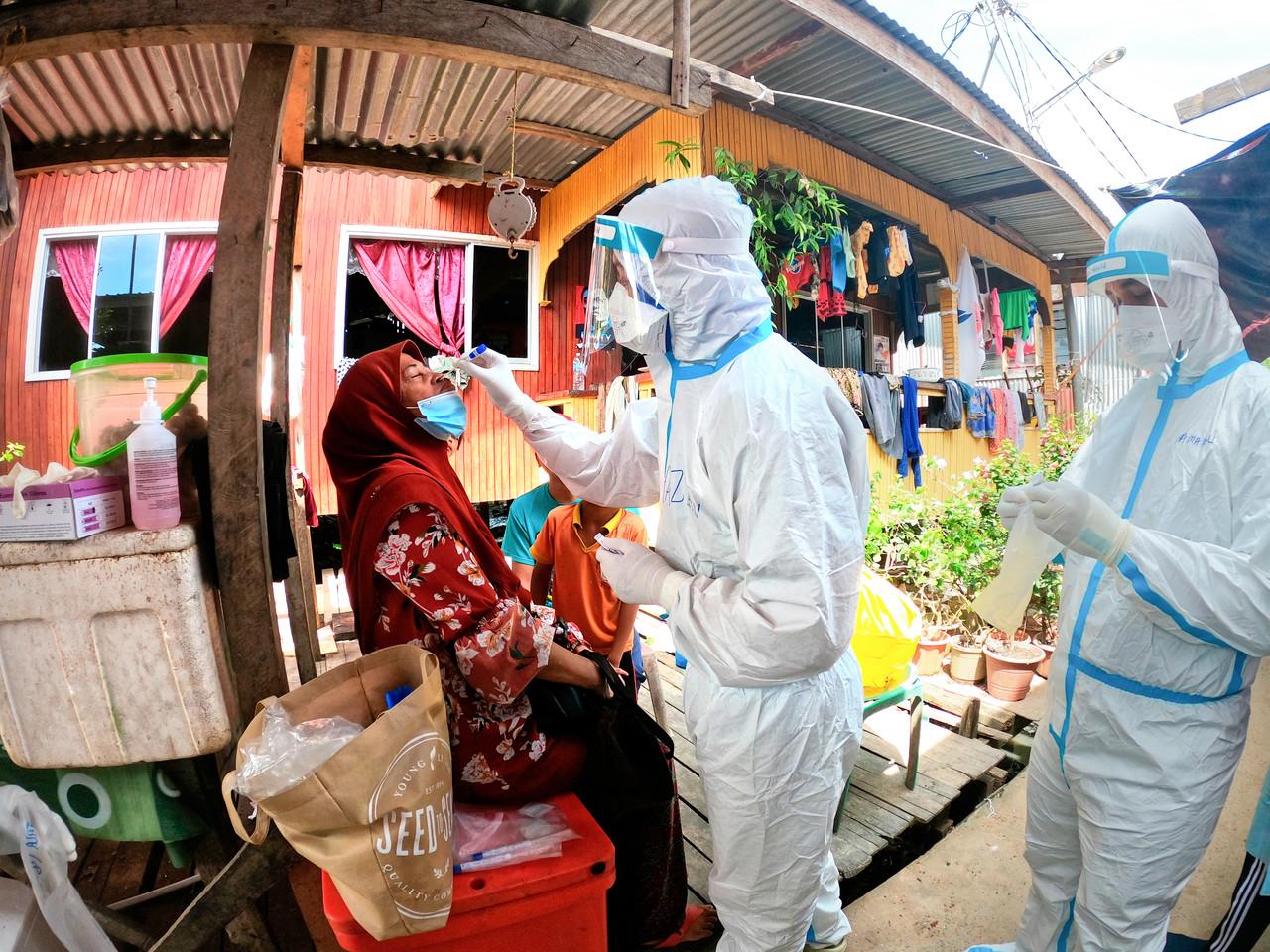 Health workers screen a resident at Kampung Lupak Meluas Darat in Sanadakan, Sabah for Covid-19. Photo: Bernama