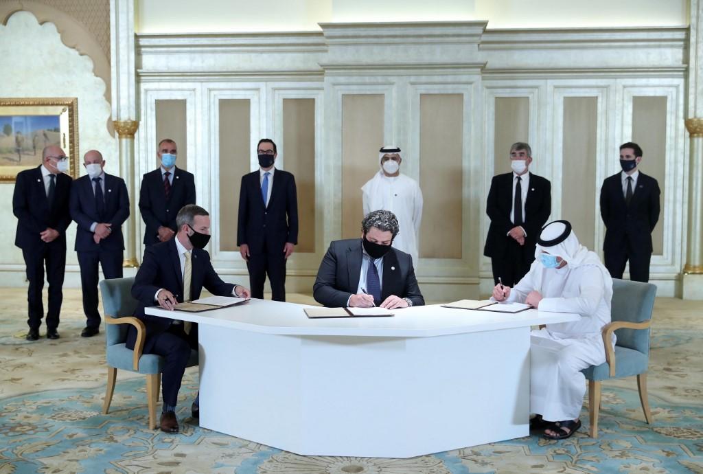 A handout image provided by United Arab Emirates News Agency shows Emirati and Israeli delegates signing an agreement at the first Abraham Accords Business Summit in Abu Dhabi on Oct 19. Photo: AFP