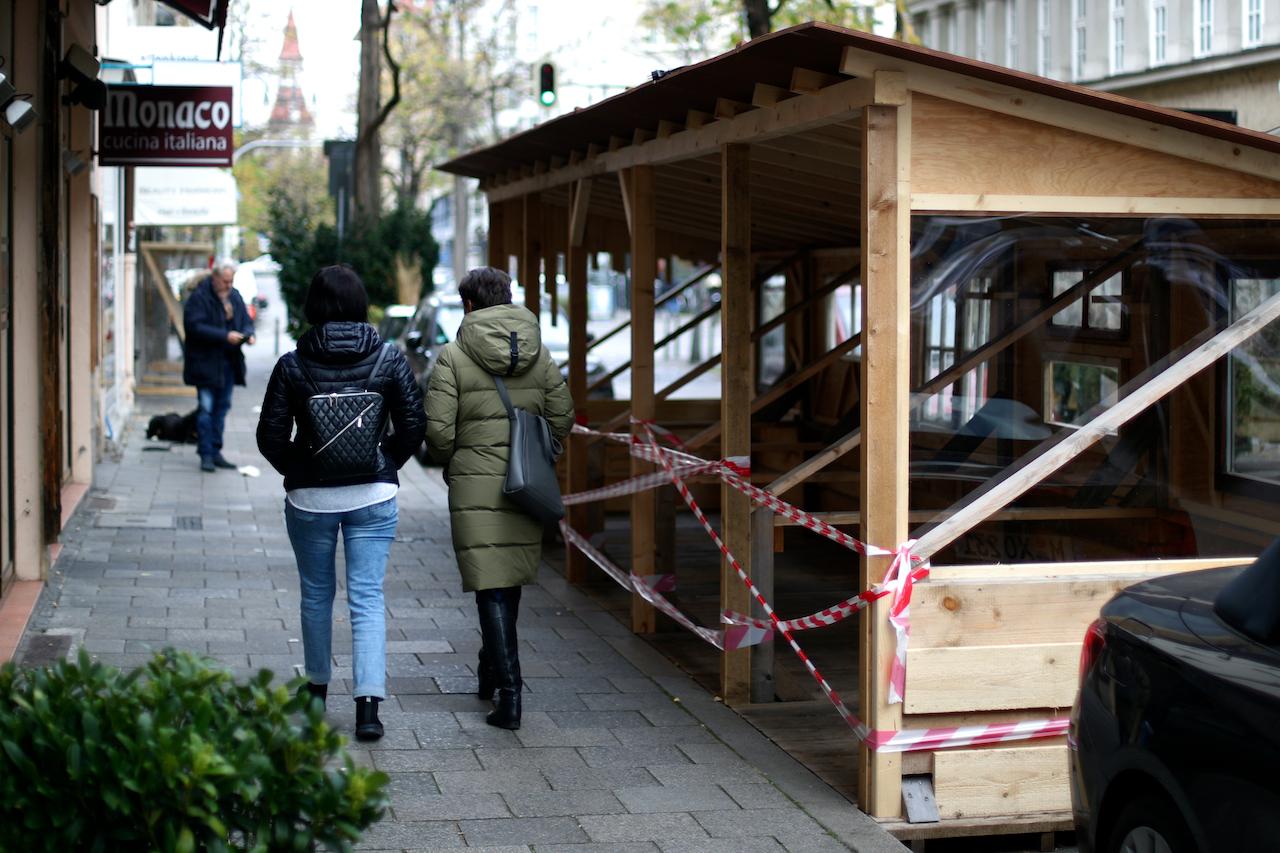 People pass a closed restaurant as the spread of Covid-19 continues in Munich, Germany, Nov 11. Photo: AP