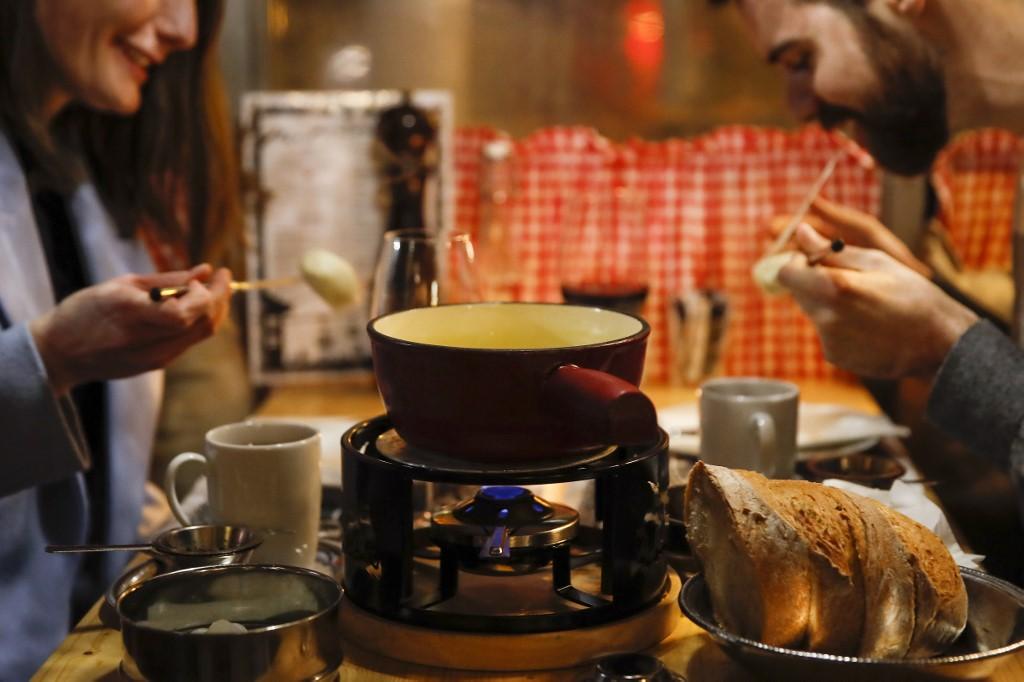 A couple enjoys a fondue, the beloved Swiss national dish at a restaurant in Bern, Nov 16. Photo: AFP