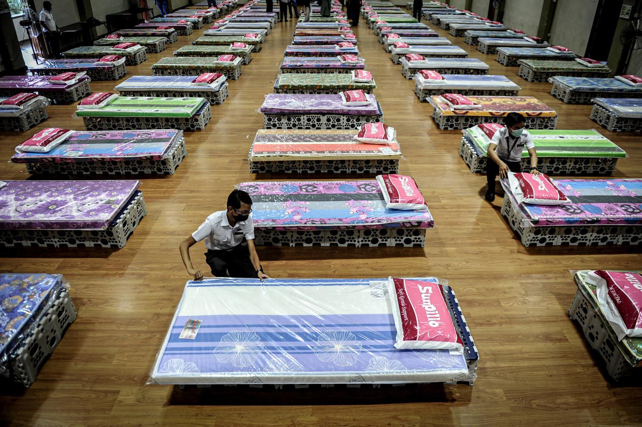 Health ministry workers arrange beds at a low-risk Covid-19 quarantine centre in George Town. Photo: Bernama