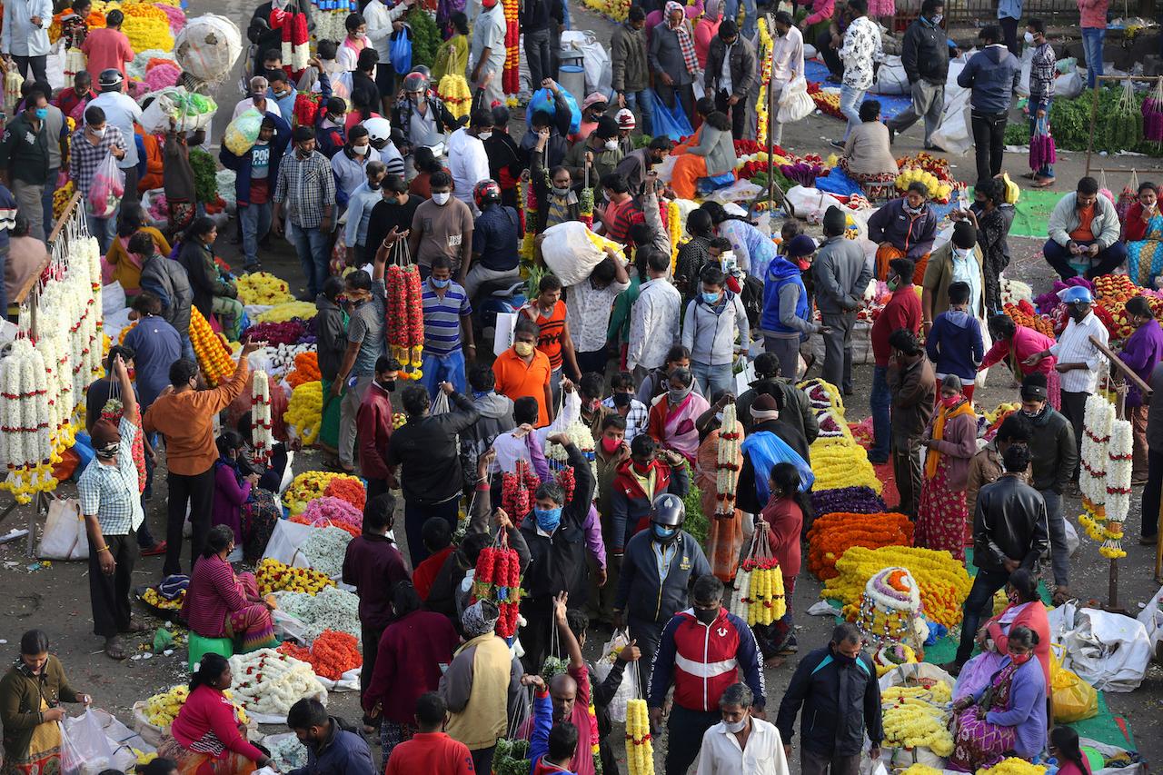Shoppers crowd at a wholesale flower market in Bengaluru, India, Nov 20. Photo: AP