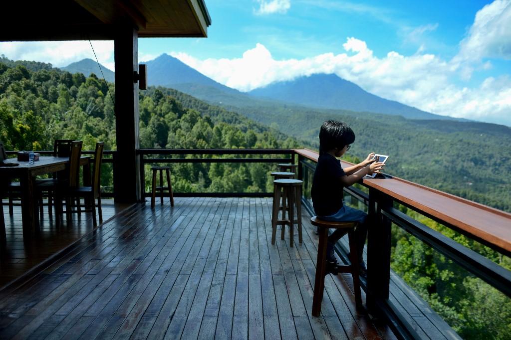 A boy uses his tablet at a villa restaurant in Bali, which has seen a downturn in tourists due to ongoing restrictions relating to the Covid-19 outbreak. Photo: AFP
