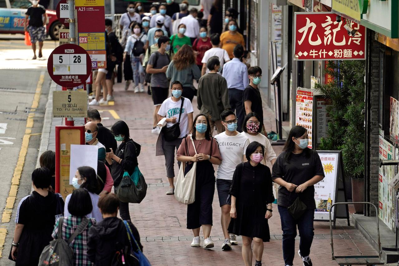 People wearing masks to protect against the coronavirus walk down a street in Hong Kong on Oct 9. Photo: AP
