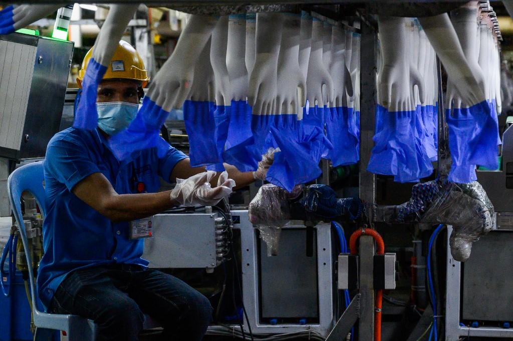 A worker inspects disposable gloves at the Top Glove factory in Shah Alam on Aug 26. Photo: AFP