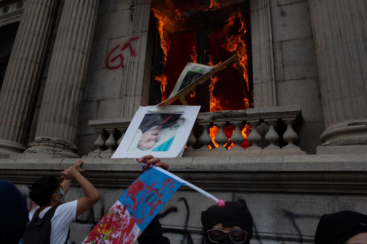 An official photo of former Congress president Eduardo Meyer is thrown out from the Congress building after protesters set a part of the building on fire, in Guatemala city, Nov 21. Photo: AP