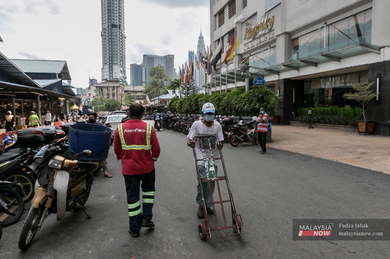 A foreign worker pushes a trolley outside the Chow Kit market in Kuala Lumpur.