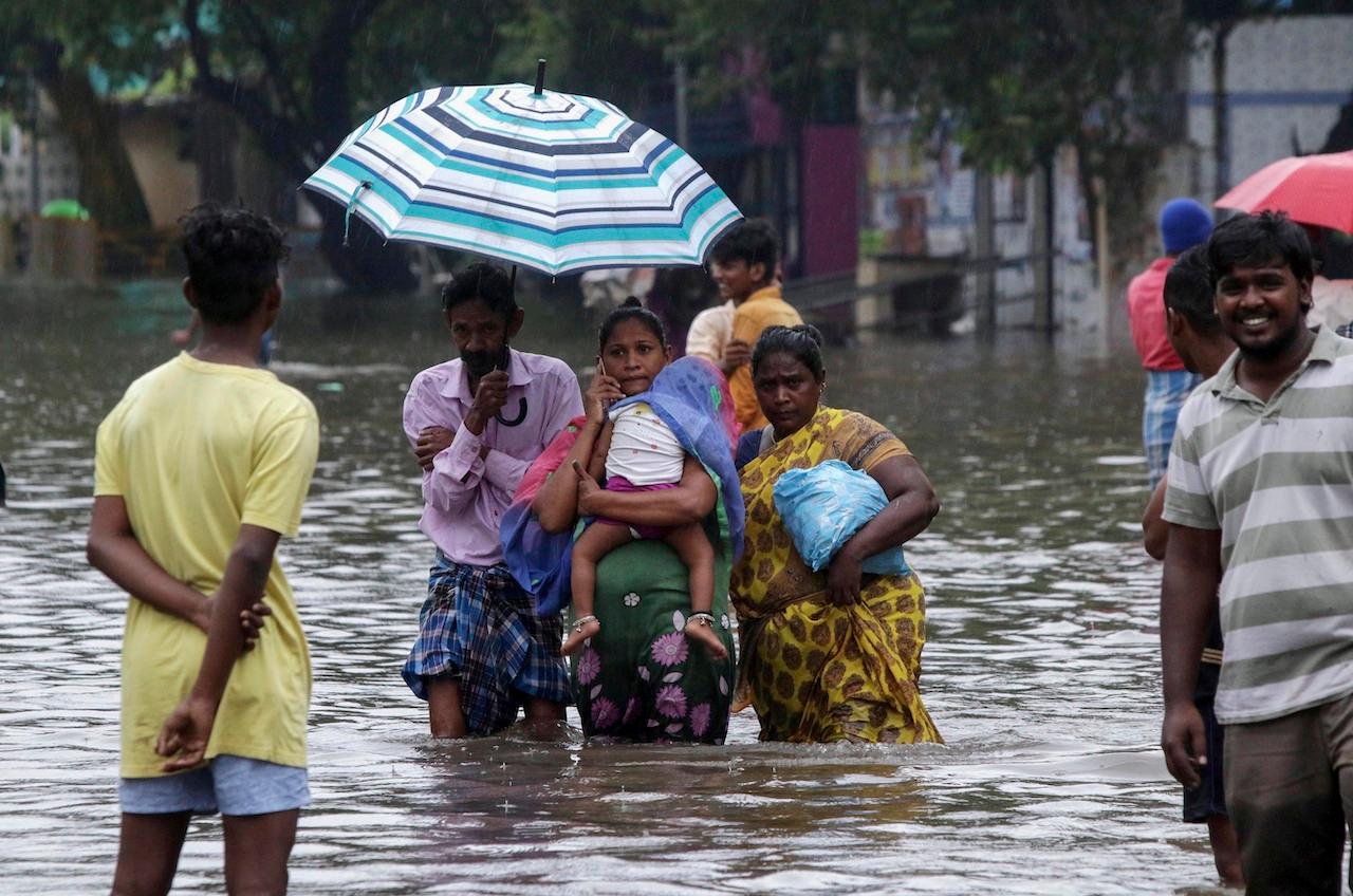 People wade through a flooded street in Chennai, India, Nov 25. Photo: AP